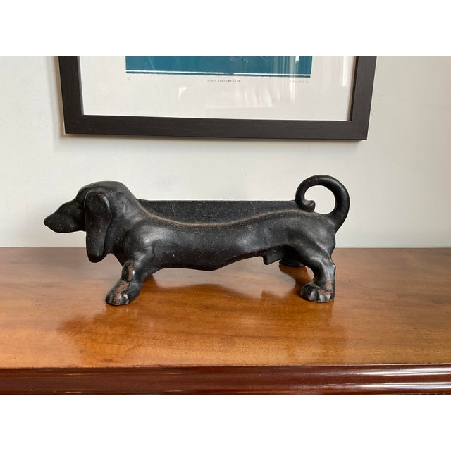 Bring charm and practical function to your entryway, porch, or garden with this substantial vintage cast iron dachshund...