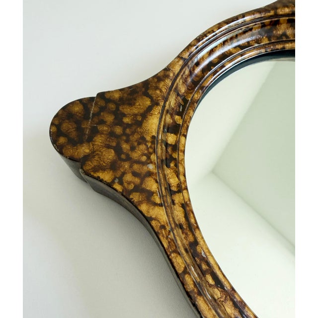 Elegant small-scale accent wall mirror with scalloped wood frame, finished in faux tortoise shell paint. Produced in the...