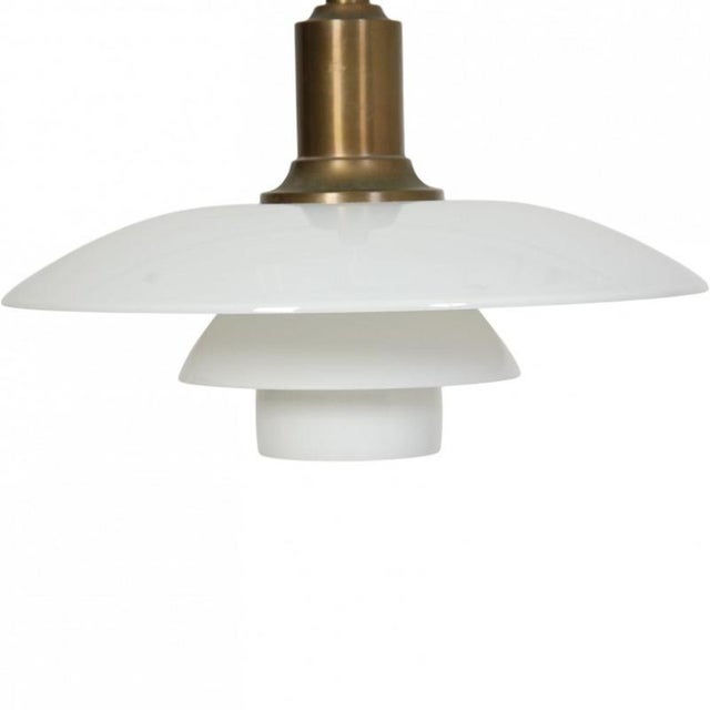 Poul Henningsen 3/2 pendant lamp with a browned brass fitting and white opal glass shades. The lamp appears in good...