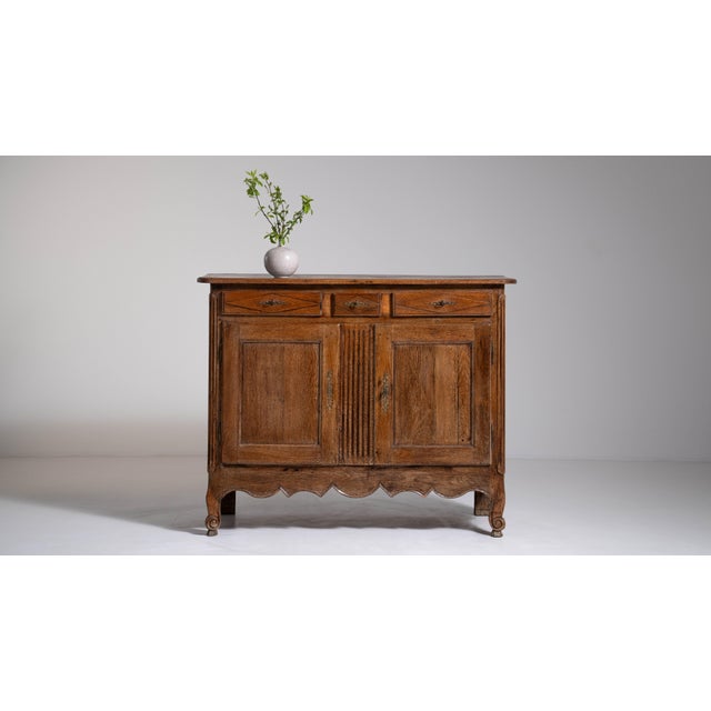 A beautiful Louis XV buffet retaining its original patina, showcasing age, texture, and authenticity. The flowing curves...