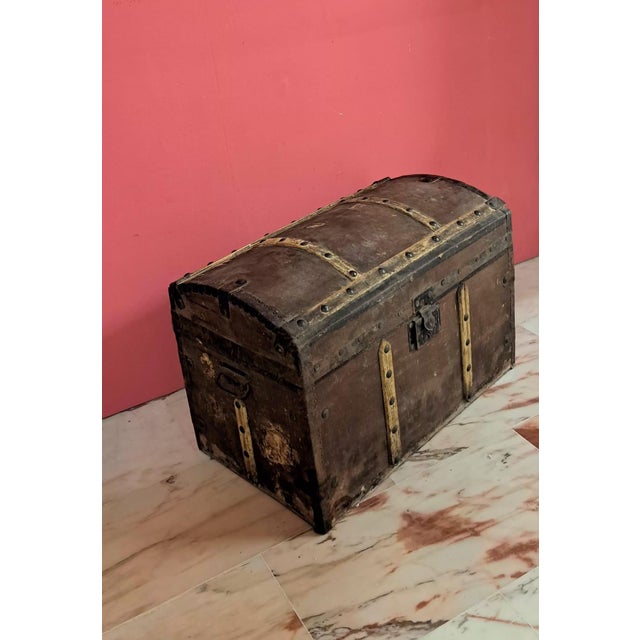 Antique travel trunk with a domed lid, wooden slats, and iron fittings dating from the late 19th century. An ideal piece...