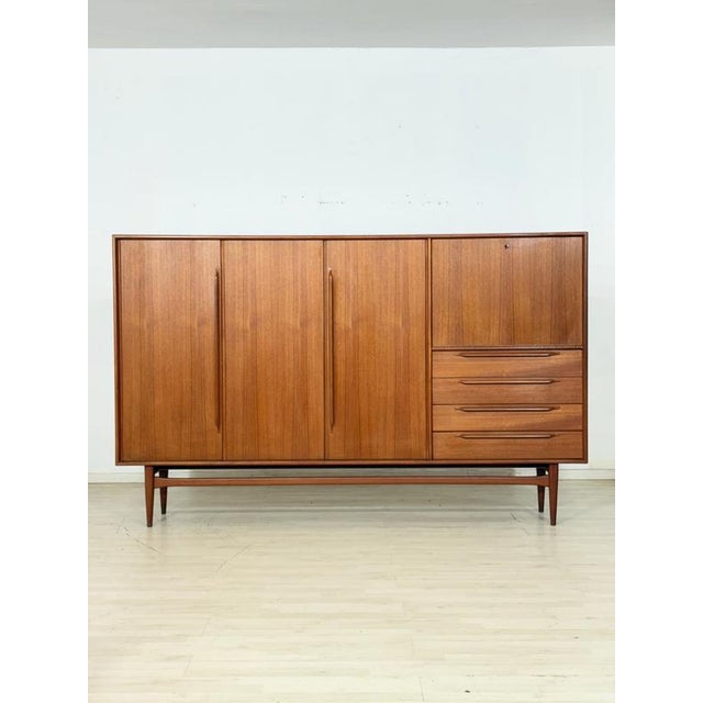 For sale is this elegant teak highboard from the 1960s, embodying timeless mid-century design with exceptional...