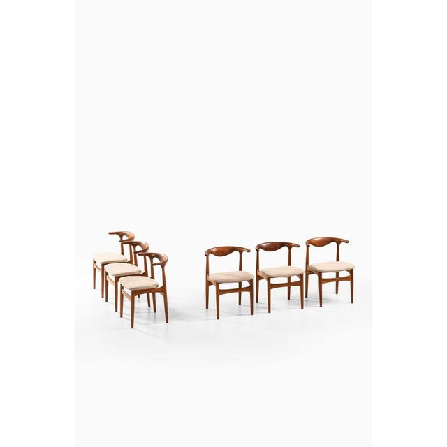 This very rare set of six dining chairs, model sm 521 — commonly known as the “cowhorn” chairs — was designed by knud...