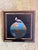 This oil on panel artwork features a bird perched atop a vividly painted globe, symbolizing a sense of global perspective...