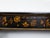 A pair of English Chinoiserie black and gold console tables from the 19th century with white marble tops. Embrace the...
