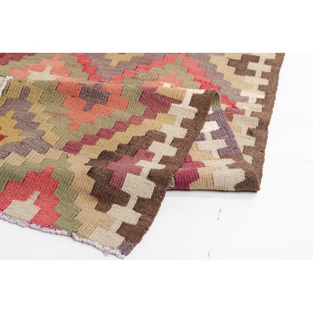 This is a vintage Turkish Oushak rug from the Mid 20th Century. The piece was hand-knotted.