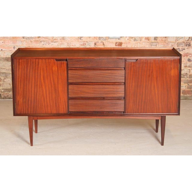 This Mid Century sideboard, crafted from solid afromosia by Richard Hornby around the 1960s, features four drawers and two...