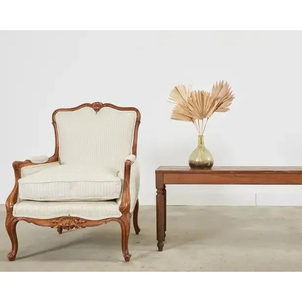 Charming pair of late 19th century carved armchairs or lounge chairs featuring newly upholstered walnut frames. The large...