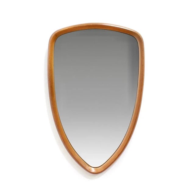 This mid-century wall mounted vertical mirror was made in Denmark during the 1960s. Produced in teak, the frame a has a...