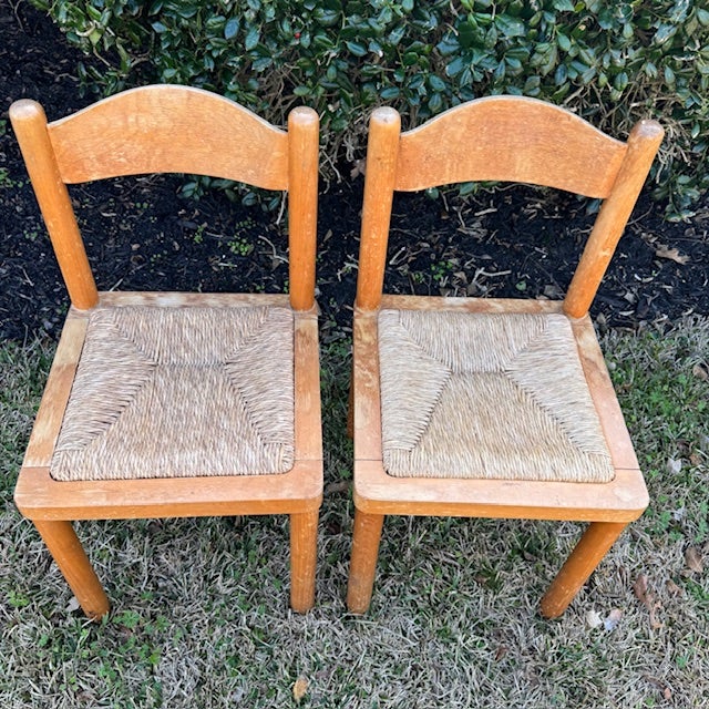 A charming set of two vintage solid wood dining chairs featuring handwoven rush seats and gently curved backrests. These...