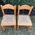 A charming set of two vintage solid wood dining chairs featuring handwoven rush seats and gently curved backrests. These...