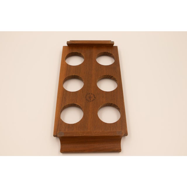 Solid walnut tray with six fitted circular cutouts holding a matched set of clear lowball glasses, each with a gently...