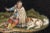 Rectangular micromosaic plate featuring a shepherd, seated and resting with his dog at his feet. The shepherd is wearing a...