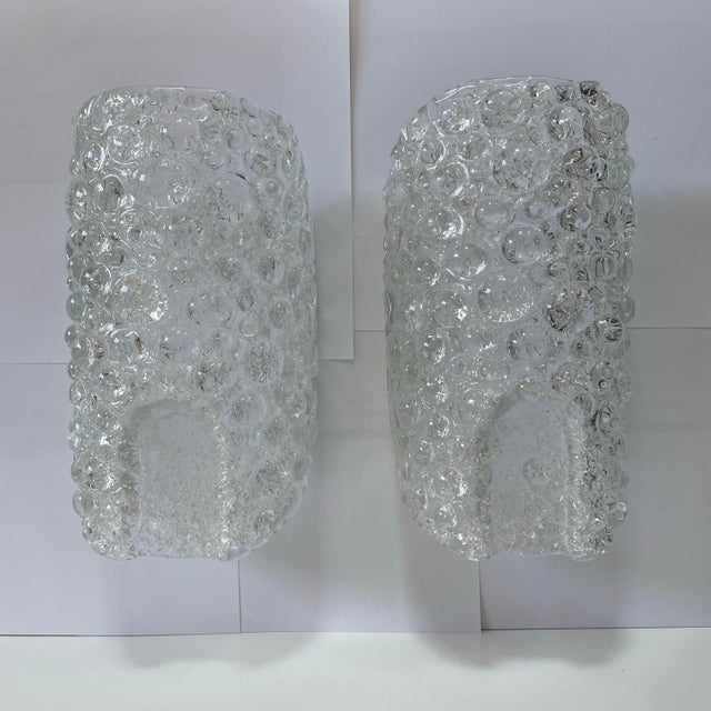 A pair of vintage 1970’s bubble Murano glass wall lamps by Hillebrand Lighting Germany. The lamps are in a thick textured...