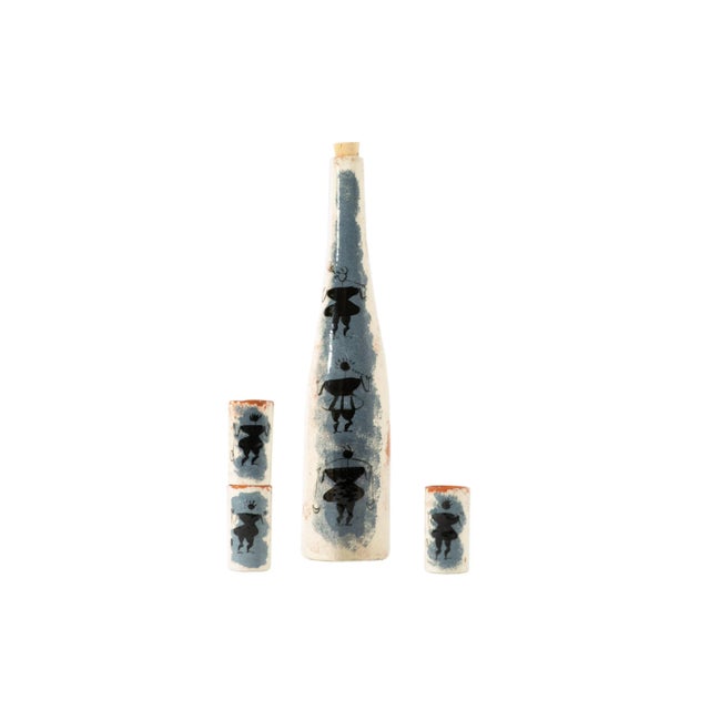 A mid-century ceramic bottle and cups by Southern California ceramic artist Ron Scharf. Three warrior figures are featured...