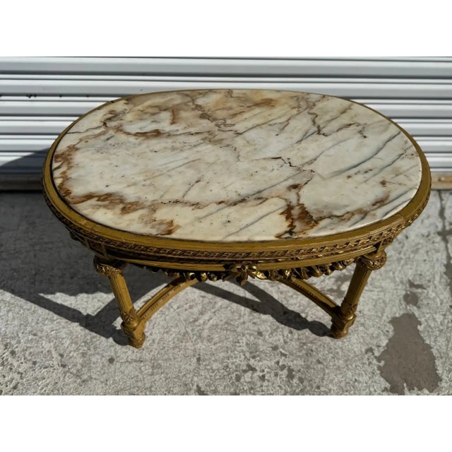 This coffee table is made in the Louis XVI style. Its oval shaped and is highly carved. The legs are columned and...