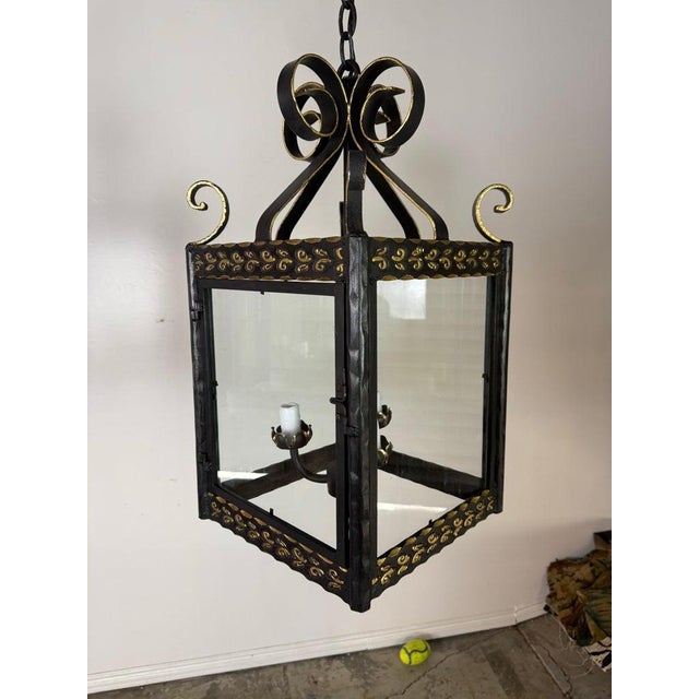 A striking pair of handcrafted wrought iron lanterns, custom made for Miamar Home, combining Old World European form with...