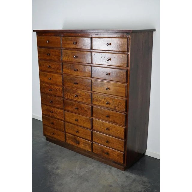 This oak apothecary cabinet with brass hardware was made in the early 20th century in France and was used in a hardware...