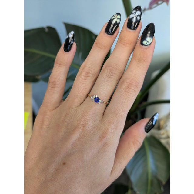 A Ceylon blue sapphire sits at the center of this dainty ring, encircled by earth-mined diamonds in solid 14K yellow gold....