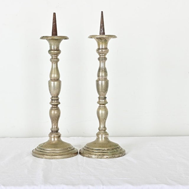 Dimensions: 20 ¼” H x 6 ¾” W x 6 ¾” D In classic Louis XVI profile, these substantial pewter "pricket" candlesticks from...