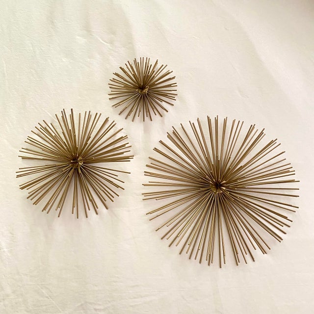 Set of 3 gold metal starburst or sea urchin wall hangings. The large one is 12" round X 3 1/2" high, Medium one is 9"...