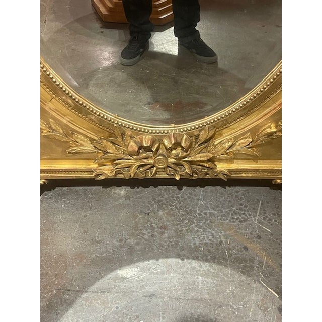 The 19th c. French Louis XVI Giltwood Mirror is a luxurious and elegant mirror with a stunning gold frame. Featuring Urns...