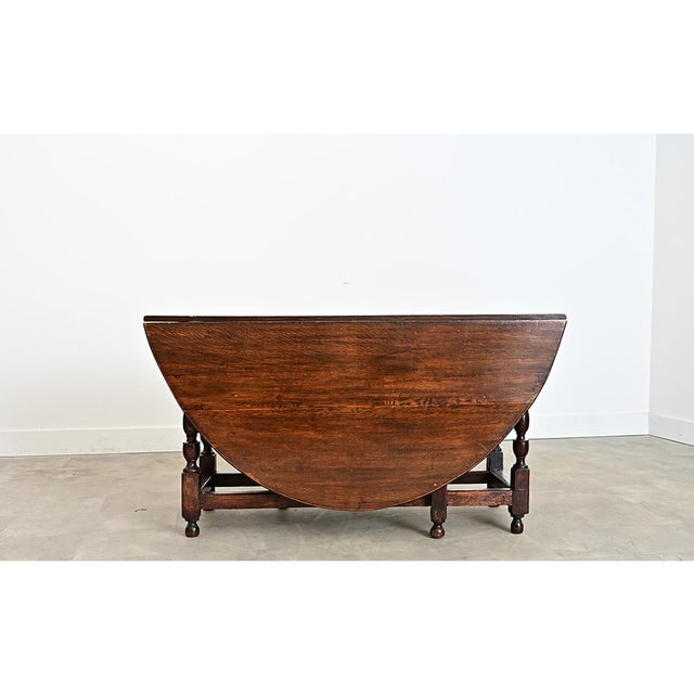 French 19th Century (or earlier) solid oak drop-leaf table with handsome baluster turned legs that can quickly switch...