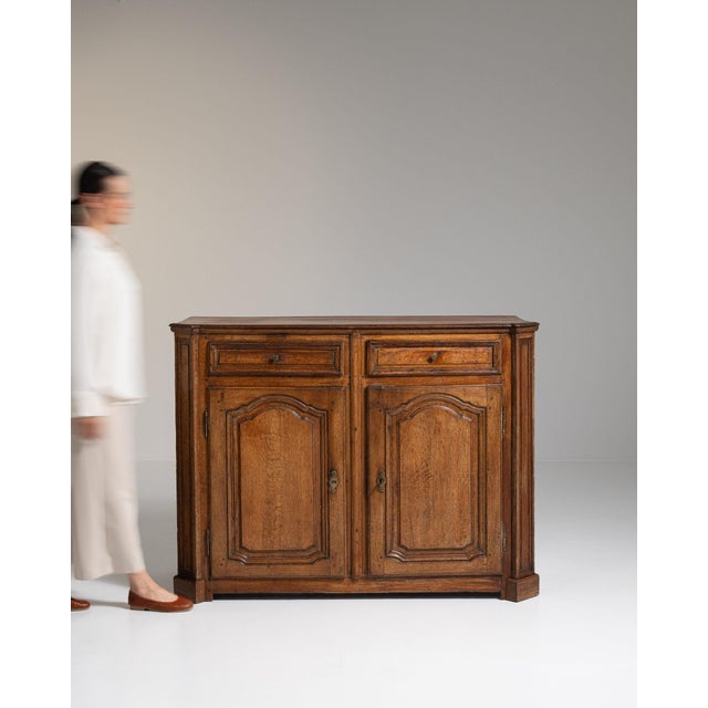 Carved oak sideboard in Honey Oak. Its honey oak finish sets off two paneled doors, two drawers, relief-carved detailing,...