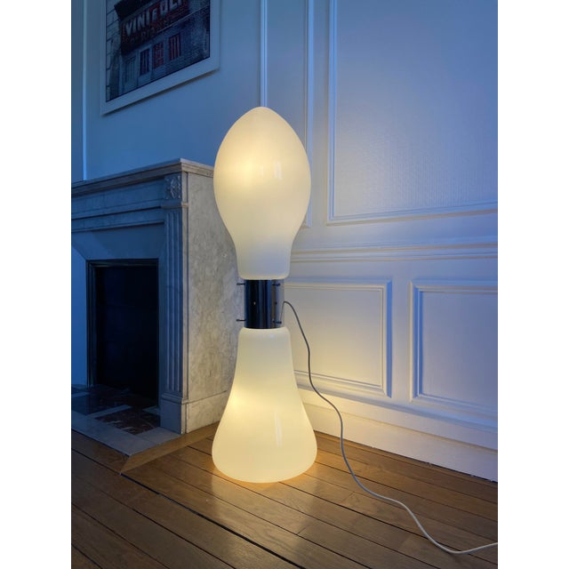 Glass and chrome-plated metal floor lamp. This floor lamp features a glass shade resting on a metal cylinder, which itself...