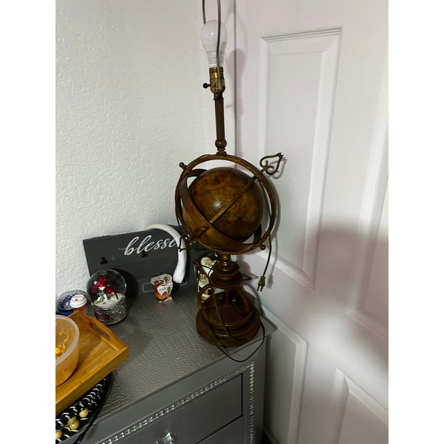 This is a striking table lamp with an antique, celestial, or nautical theme, designed to resemble an armillary sphere. The...