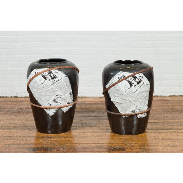A large contemporary Thai exterior flower vase with black patina, rope and newspaper motifs. We have two available, priced...