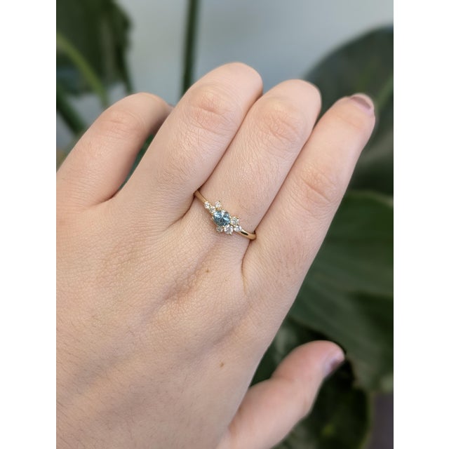 A delicate beauty, this dainty ring showcases a 0.32ct round Cambodian blue zircon, offset by shimmering earth-mined...