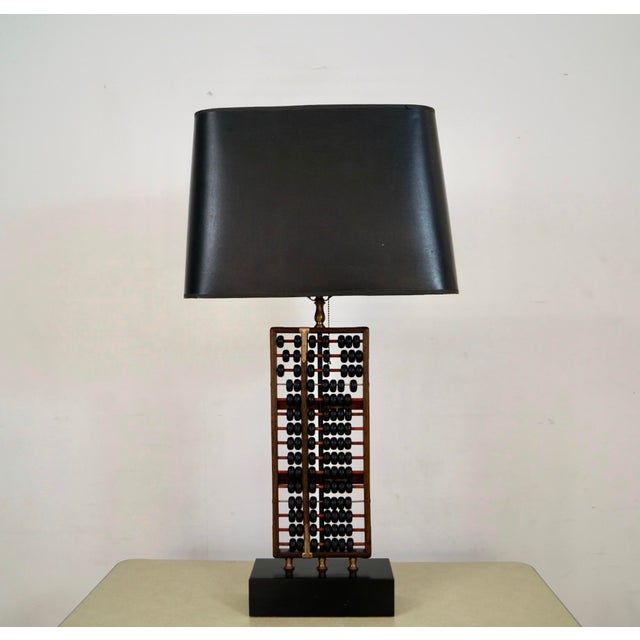 Vintage 1950's Mid century Modern table lamp for sale. It's made of solid rosewood, and has solid brass accent brackets on...