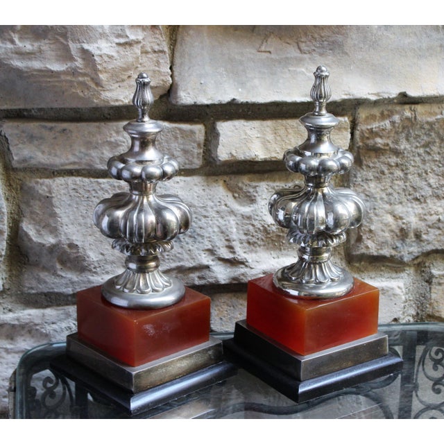 Stunning pair of obelisks with silver-plated elements with oxblood red and wood bases. Signed Bombay Company. Sold as a...