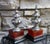 Stunning pair of obelisks with silver-plated elements with oxblood red and wood bases. Signed Bombay Company. Sold as a...