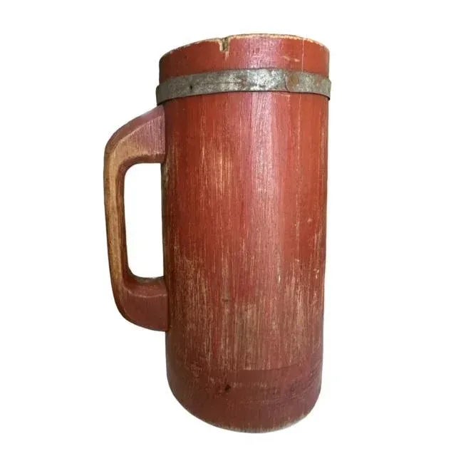 Primitve German wood stein with handle. Metal band around top of stein.