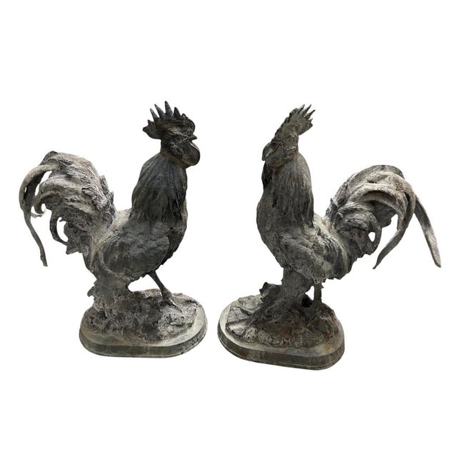 A striking and highly decorative pair of vintage cast iron rooster statues, perfectly suited to bring architectural...