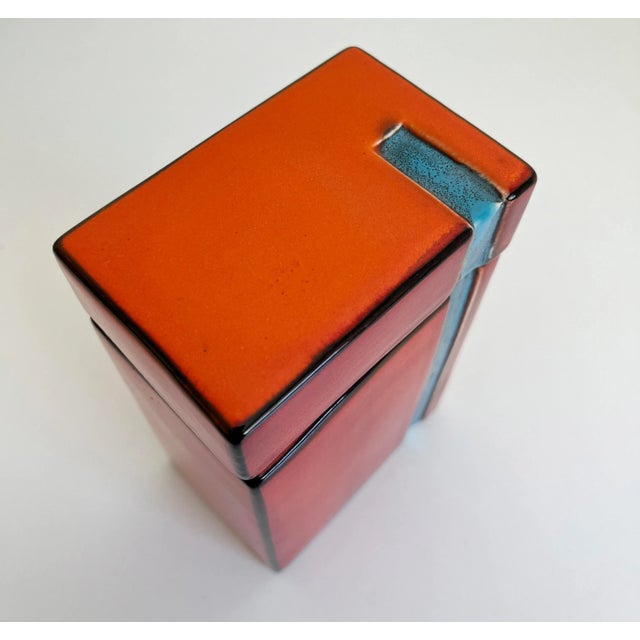 Vibrant shades of red, orange, and blue in this ceramic lidded storage canister / box. Likely produced in West Germany...