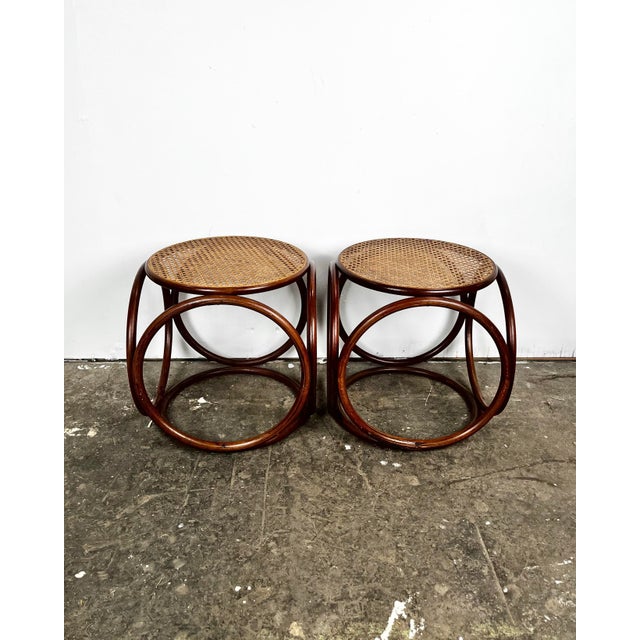 Mid century pair of Thonet style bentwood round ottomans with cane tops. Round bent wood frames. Great as stools, or as...