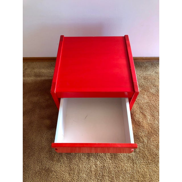 Exceptionally rare modern night table in bright red that perfectly embodies the warm colours, soft lines, and...