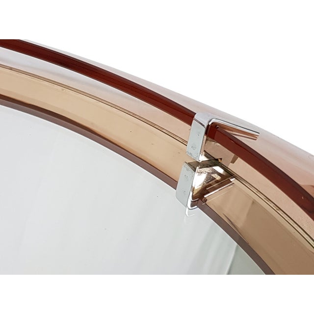 This round wall mirror was produced in Italy around the 1960s. It it made from a wooden and metal structure with a...