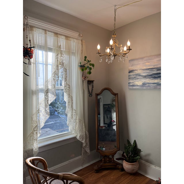 Early 20th century solid brass chandelier with floral details and original crystal drops. This piece retains all original...