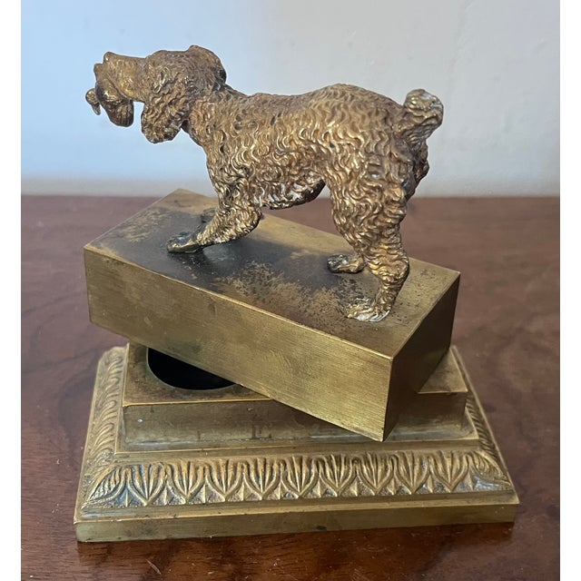 Antique 19th century French Charles X bronze hunting dog inkwell retrieving a bird in his mouth. The dog stands atop a...