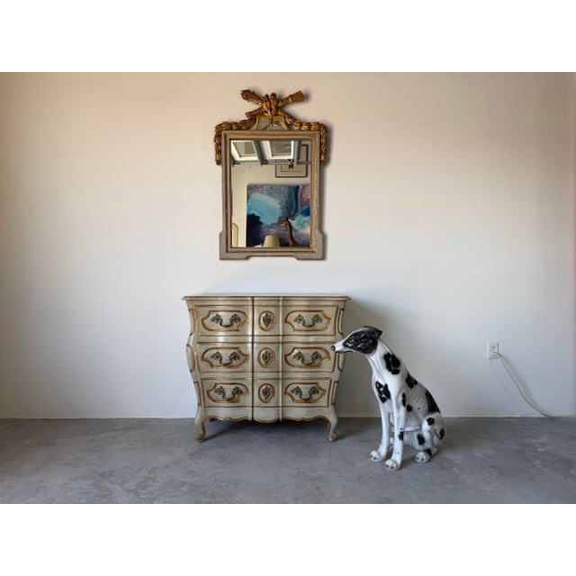Elegant vintage Louis XV style bombe chest featuring a gracefully serpentine silhouette, shaped top, and cabriole-style...