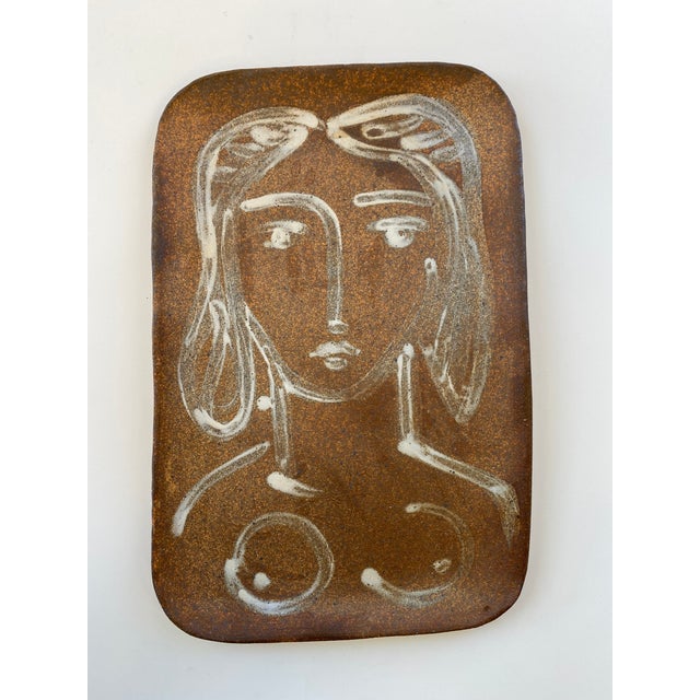Slab built earthenware platter of speckled dark clay, featuring a cubist figure in manner of Picasso painted in white...