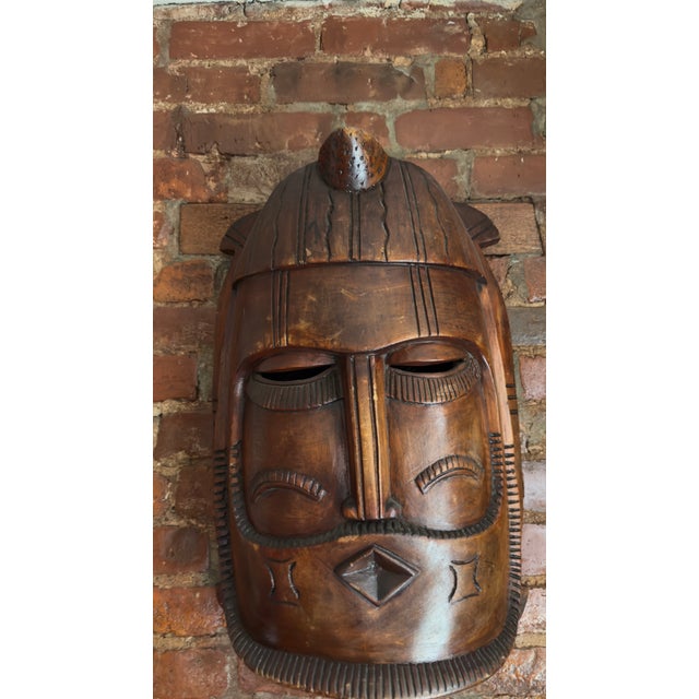 African style carved wood wall mask inspired by traditional West African mask making practices from regions including...