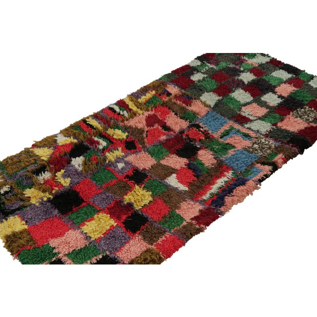 Hand-knotted in wool circa 1950-1960, this 3x6 vintage Moroccan runner rug with polychromatic geometric patterns, hails...