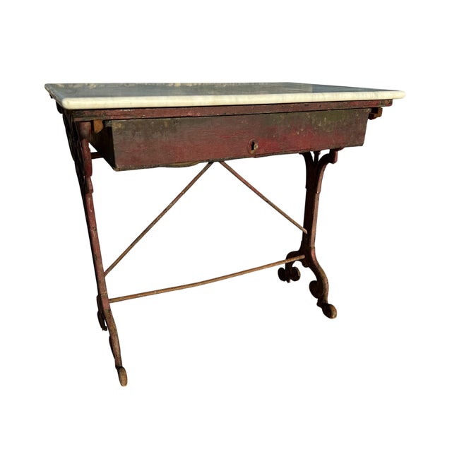 Bistro table from a Parisian brasserie dating from the 1900s, with a cast iron and wrought iron base in burgundy color and...