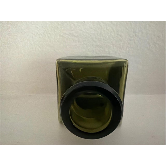 Antique Olive Green Square Inkwell is made of heavy green glass. The bottle itself is square with a rounded opening at the...