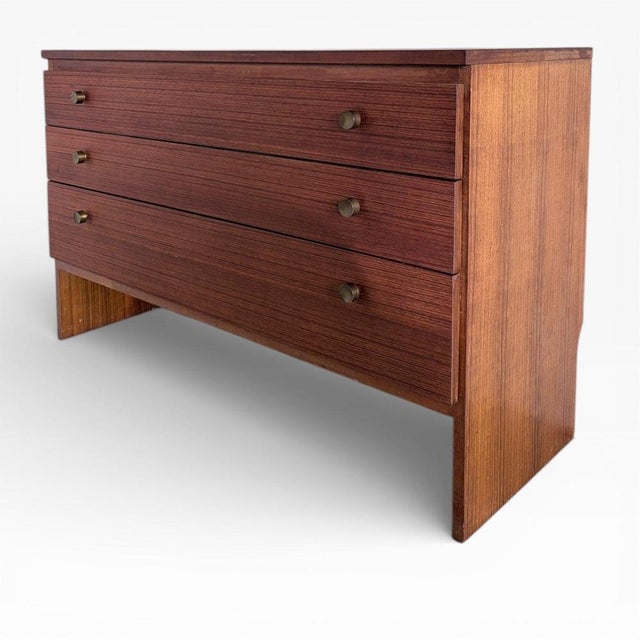 This mid-century teak dresser is a vintage Meredew chest designed to offer compact bedroom storage with style and...